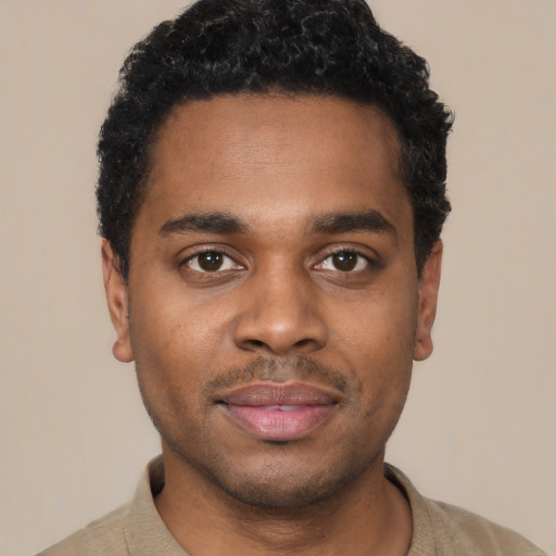 Joyful black young-adult male with short  black hair and brown eyes