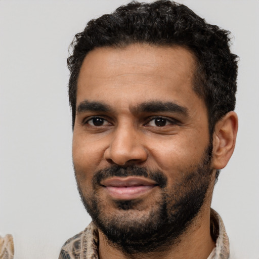 Joyful black young-adult male with short  black hair and brown eyes