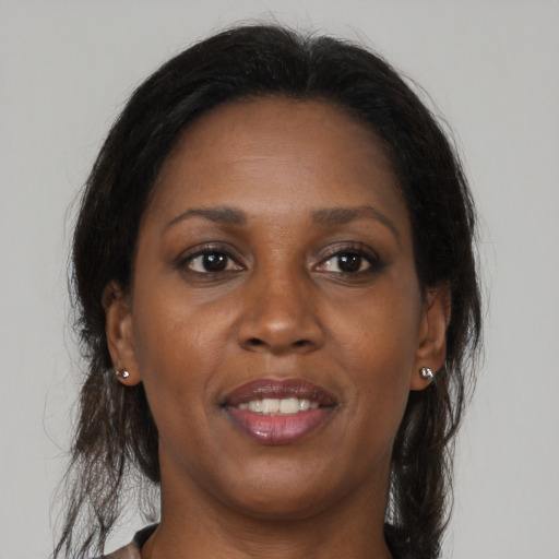 Joyful black adult female with long  brown hair and brown eyes