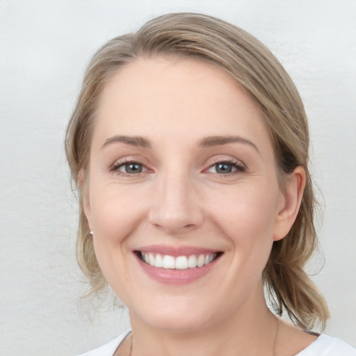 Joyful white young-adult female with medium  brown hair and blue eyes