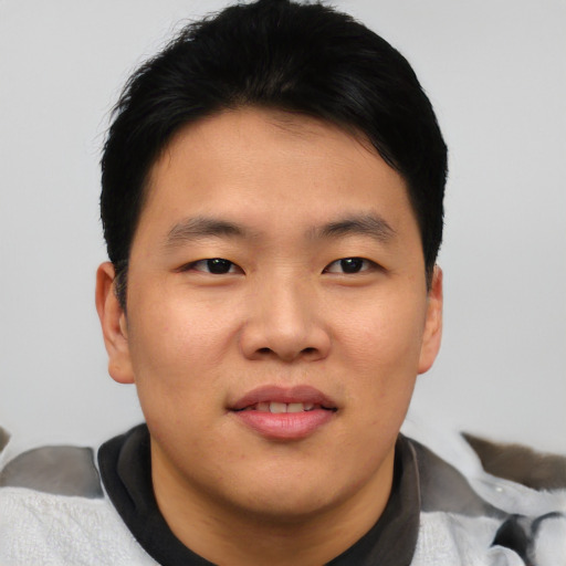 Joyful asian young-adult male with short  black hair and brown eyes