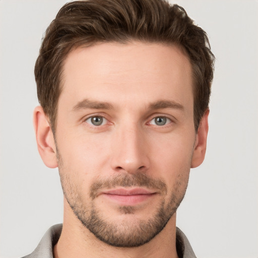 Joyful white young-adult male with short  brown hair and grey eyes