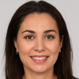 Joyful white young-adult female with long  brown hair and brown eyes