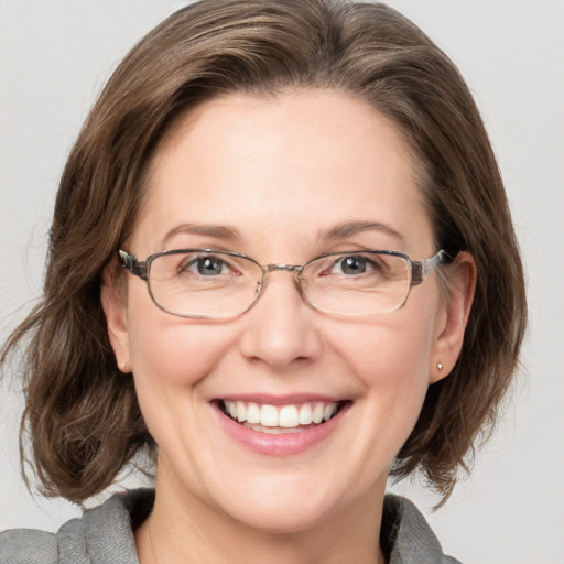 Joyful white adult female with medium  brown hair and blue eyes