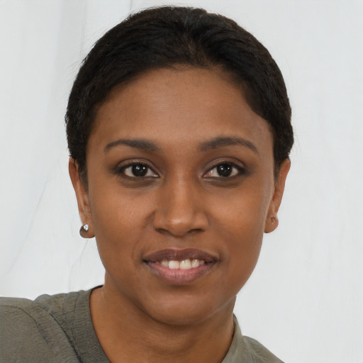 Joyful black young-adult female with short  brown hair and brown eyes