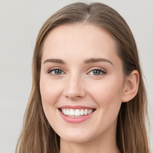 Joyful white young-adult female with long  brown hair and blue eyes