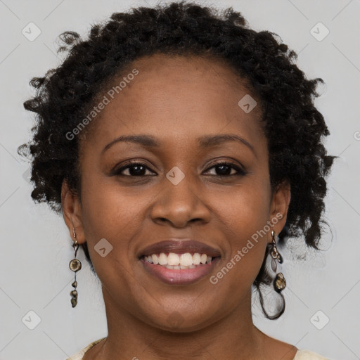 Joyful black young-adult female with long  brown hair and brown eyes