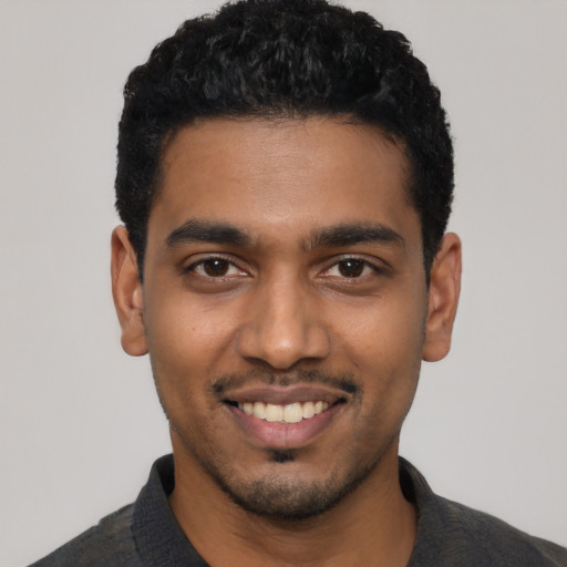 Joyful latino young-adult male with short  black hair and brown eyes