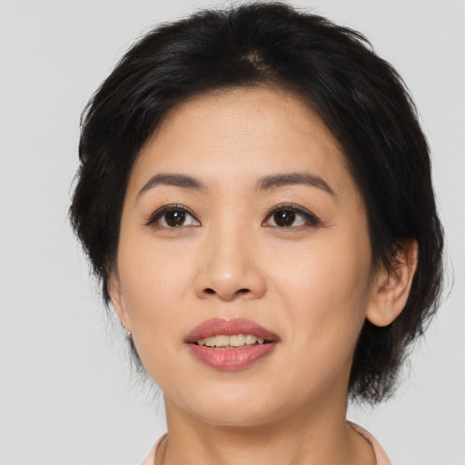 Joyful asian young-adult female with medium  black hair and brown eyes