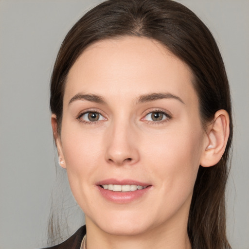 Joyful white young-adult female with long  brown hair and brown eyes