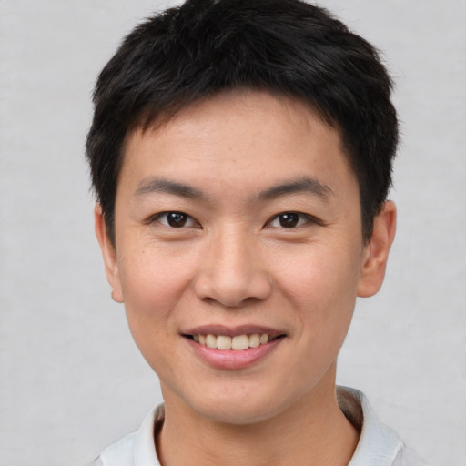 Joyful asian young-adult male with short  brown hair and brown eyes