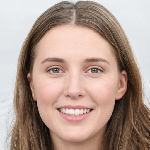 Joyful white young-adult female with long  brown hair and grey eyes