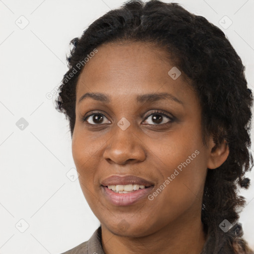 Joyful black young-adult female with long  brown hair and brown eyes