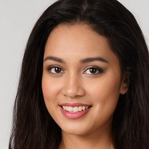 Joyful white young-adult female with long  brown hair and brown eyes