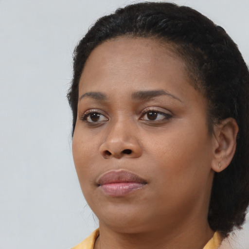 Joyful black young-adult female with medium  black hair and brown eyes