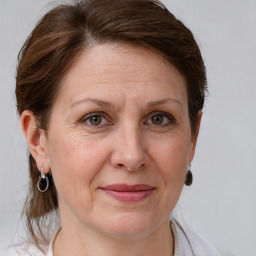 Joyful white adult female with medium  brown hair and grey eyes