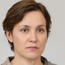 Joyful white adult female with medium  brown hair and grey eyes