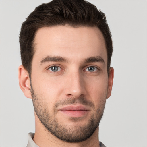 Joyful white young-adult male with short  brown hair and grey eyes