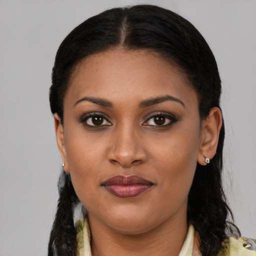 Joyful black young-adult female with long  brown hair and brown eyes