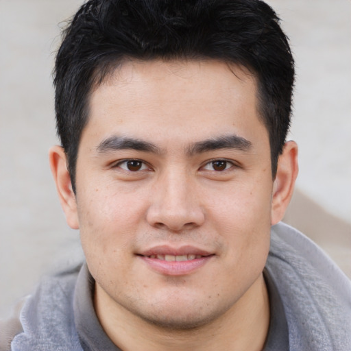 Joyful asian young-adult male with short  brown hair and brown eyes