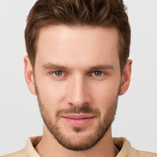 Joyful white young-adult male with short  brown hair and grey eyes