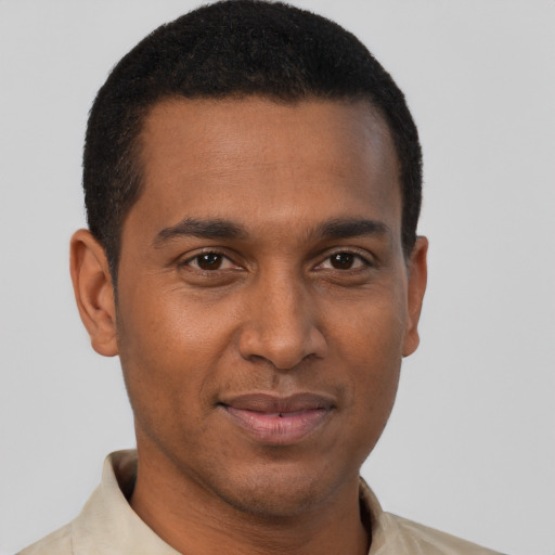 Joyful black young-adult male with short  brown hair and brown eyes