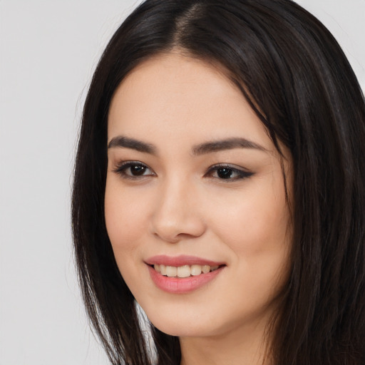 Joyful asian young-adult female with long  brown hair and brown eyes