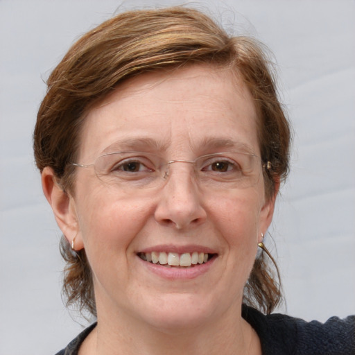 Joyful white adult female with medium  brown hair and blue eyes