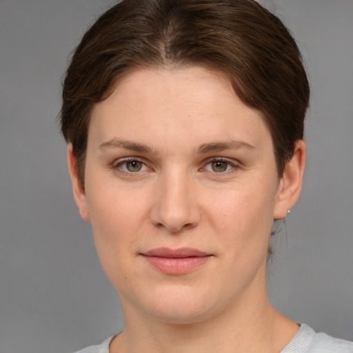 Joyful white young-adult female with short  brown hair and grey eyes