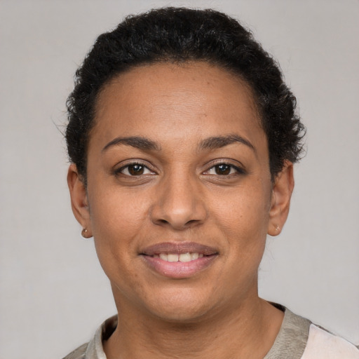 Joyful latino young-adult female with short  black hair and brown eyes