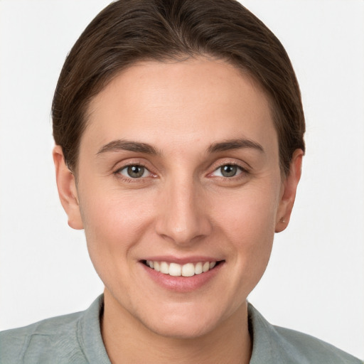 Joyful white young-adult female with short  brown hair and grey eyes