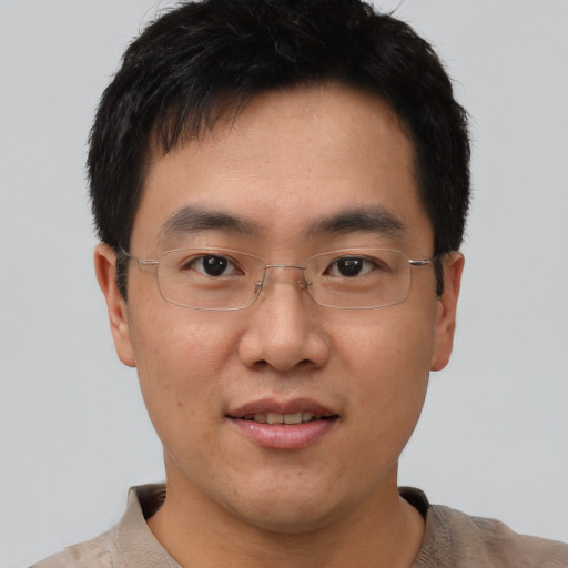Joyful asian young-adult male with short  black hair and brown eyes