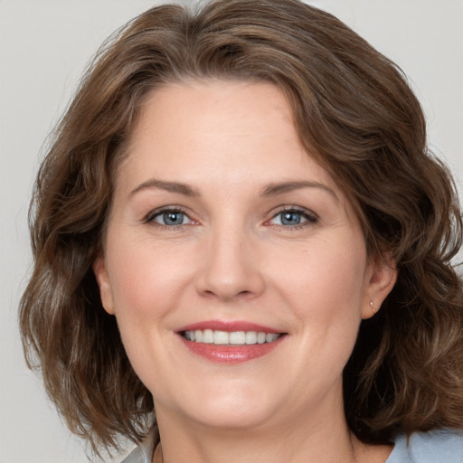 Joyful white adult female with medium  brown hair and grey eyes