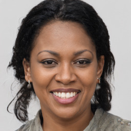 Joyful black adult female with long  brown hair and brown eyes