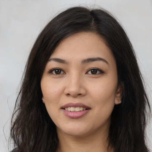 Joyful asian young-adult female with long  brown hair and brown eyes