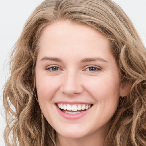 Joyful white young-adult female with long  brown hair and blue eyes