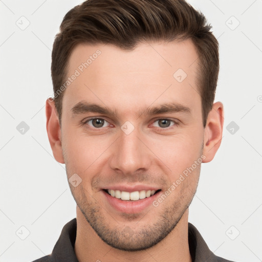 Joyful white young-adult male with short  brown hair and grey eyes