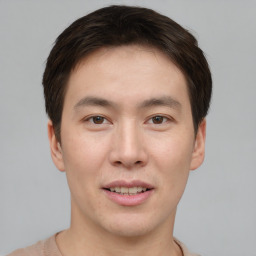 Joyful asian young-adult male with short  brown hair and brown eyes