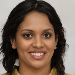 Joyful black young-adult female with long  brown hair and brown eyes