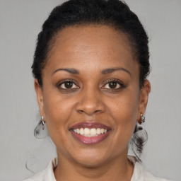 Joyful black adult female with medium  brown hair and brown eyes