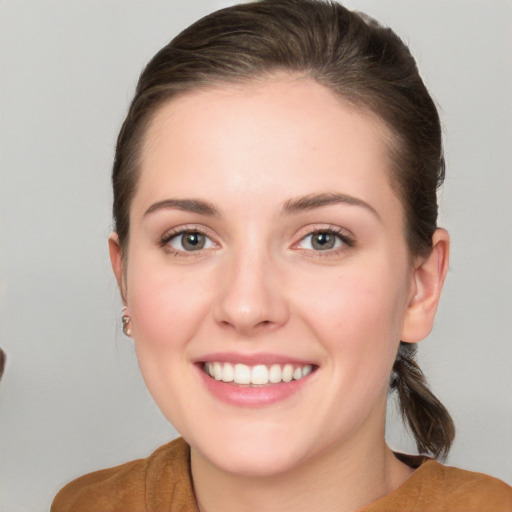 Joyful white young-adult female with medium  brown hair and grey eyes