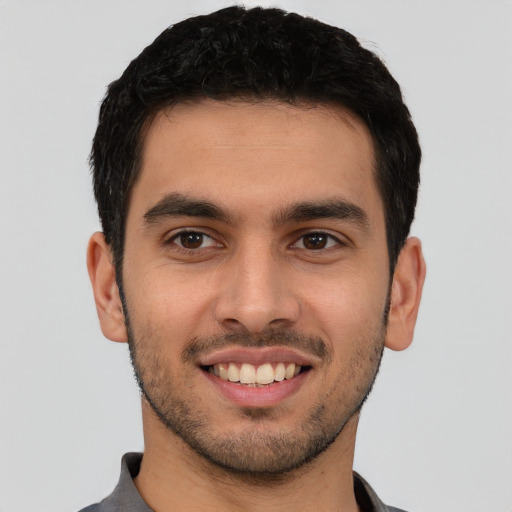 Joyful latino young-adult male with short  black hair and brown eyes