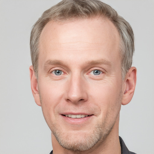 Joyful white adult male with short  brown hair and blue eyes