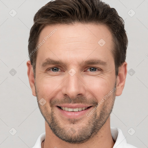 Joyful white young-adult male with short  brown hair and grey eyes