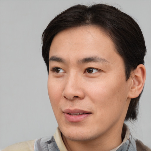 Joyful asian young-adult male with short  brown hair and brown eyes