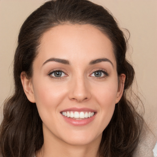 Joyful white young-adult female with long  brown hair and brown eyes