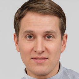 Joyful white young-adult male with short  brown hair and grey eyes