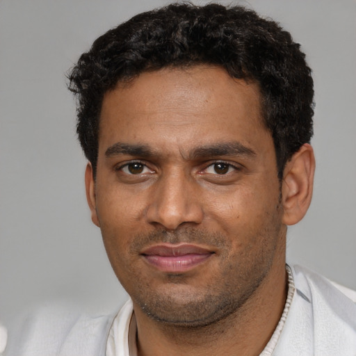Joyful black adult male with short  brown hair and brown eyes