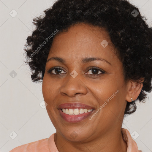 Joyful black adult female with short  brown hair and brown eyes