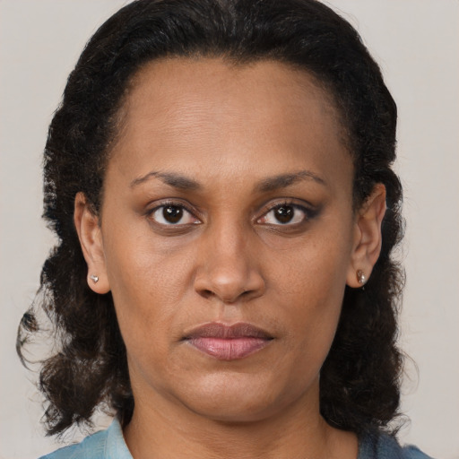 Joyful black adult female with medium  brown hair and brown eyes